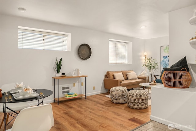 living area with wood finished floors, baseboards, and a wealth of natural light