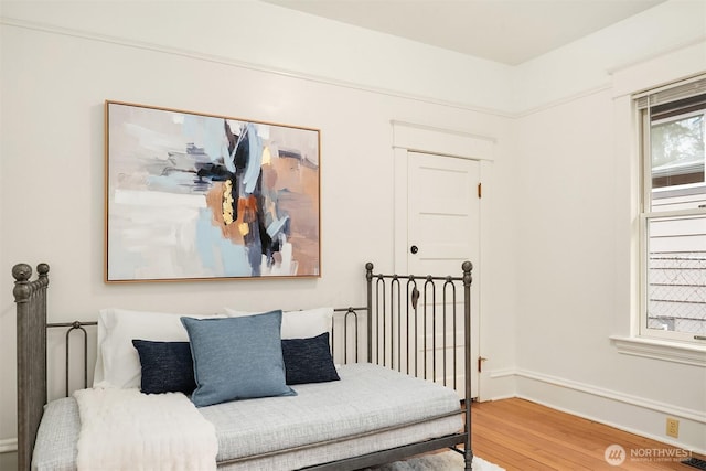 bedroom featuring wood finished floors and baseboards