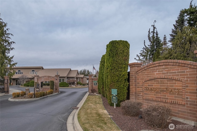 view of road with curbs and a gated entry