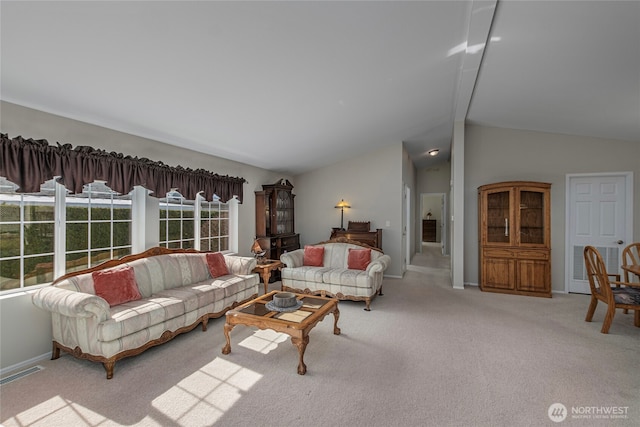 living area with baseboards, visible vents, lofted ceiling, and light carpet