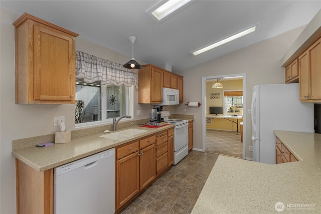 kitchen with stone finish floor, a sink, white appliances, light countertops, and lofted ceiling