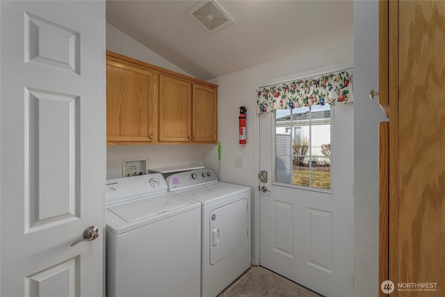 washroom with cabinet space, visible vents, and washer and clothes dryer