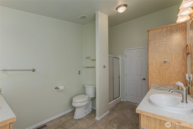 bathroom with toilet, a stall shower, and vanity