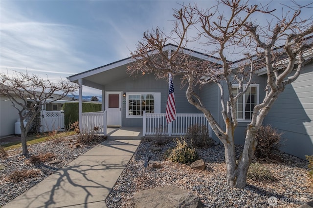 view of front of home featuring a porch and fence