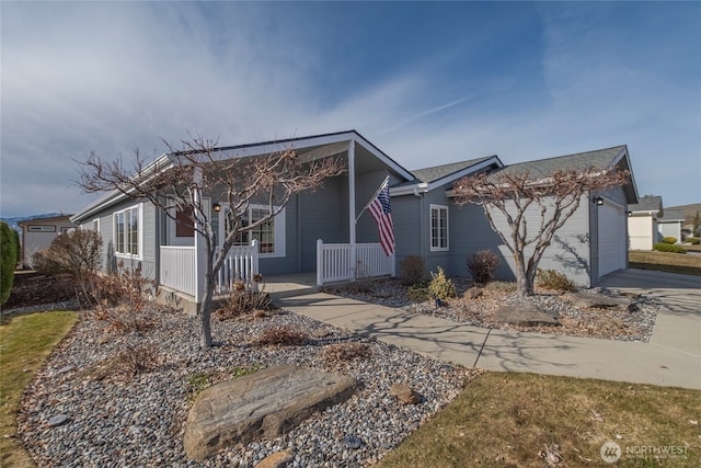 view of front facade featuring a porch, an attached garage, and driveway