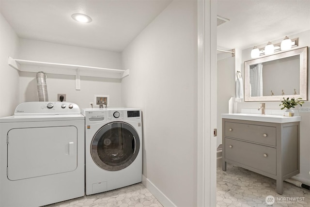 clothes washing area with washer and clothes dryer and baseboards