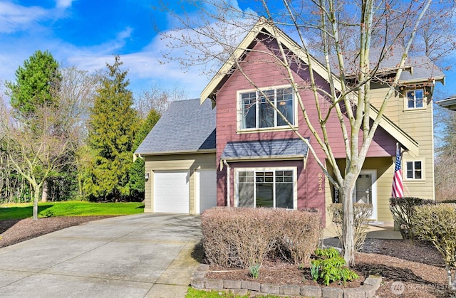 view of front facade featuring driveway, an attached garage, and roof with shingles