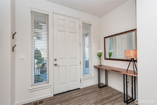 foyer entrance featuring wood finished floors, visible vents, and baseboards