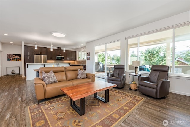 living room with recessed lighting, baseboards, and wood finished floors