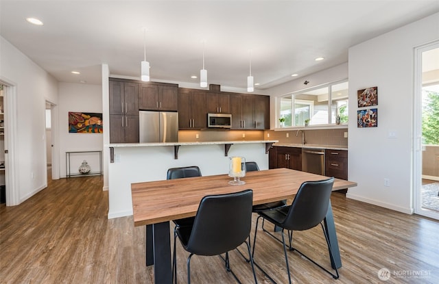 dining space with wood finished floors, recessed lighting, a healthy amount of sunlight, and baseboards