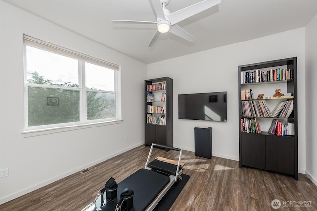 workout room featuring a ceiling fan, wood finished floors, visible vents, and baseboards