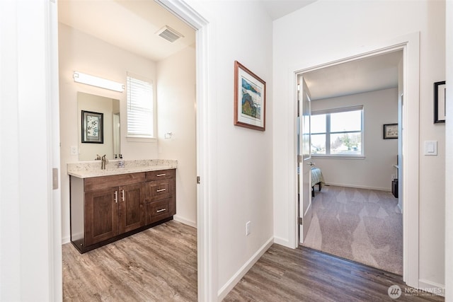 bathroom featuring visible vents, ensuite bathroom, baseboards, and wood finished floors