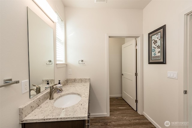 bathroom with vanity, visible vents, wood finished floors, and baseboards