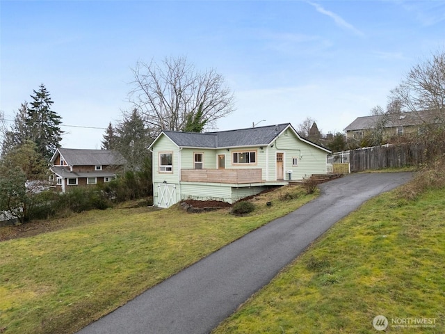 view of front of house with a front lawn and fence