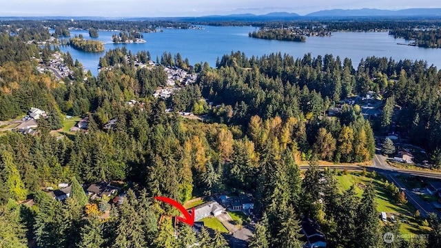 aerial view featuring a water view and a wooded view
