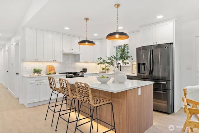 kitchen featuring a center island, stainless steel refrigerator with ice dispenser, tasteful backsplash, light countertops, and white cabinetry