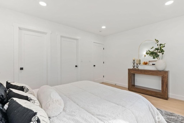 bedroom with baseboards, recessed lighting, and light wood-style floors