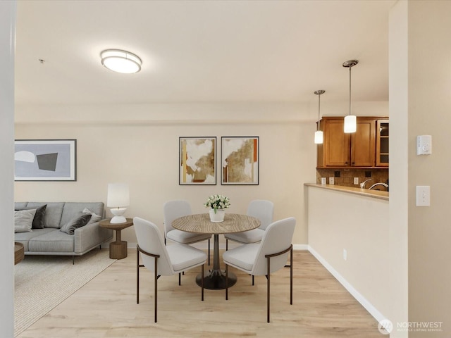 dining space with light wood-style floors and baseboards