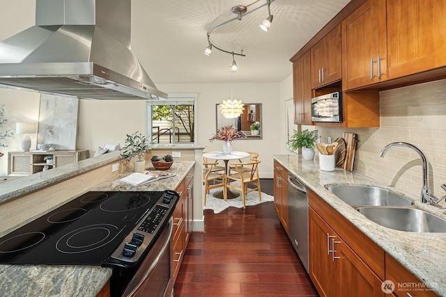 kitchen featuring dark wood-style floors, brown cabinetry, a sink, ventilation hood, and dishwasher