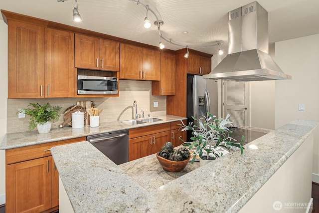 kitchen featuring appliances with stainless steel finishes, brown cabinets, island exhaust hood, and a sink