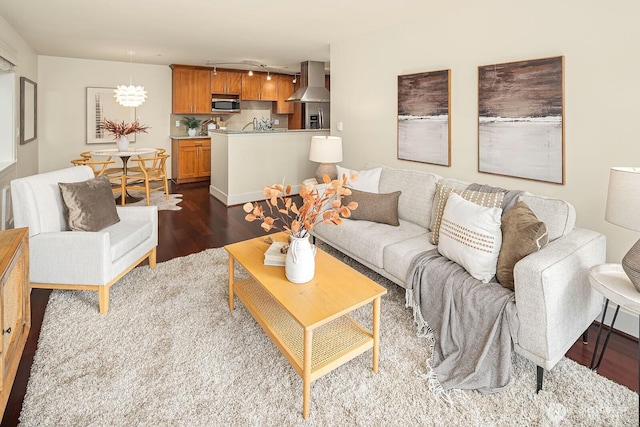 living room featuring a chandelier, dark wood-style flooring, and rail lighting