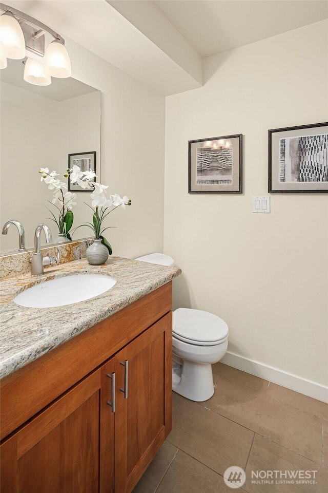 bathroom with toilet, baseboards, vanity, and tile patterned floors