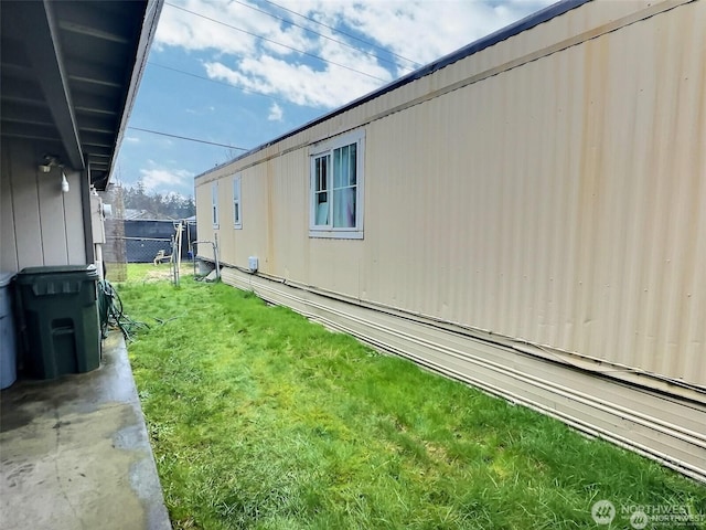 view of property exterior with fence and a lawn