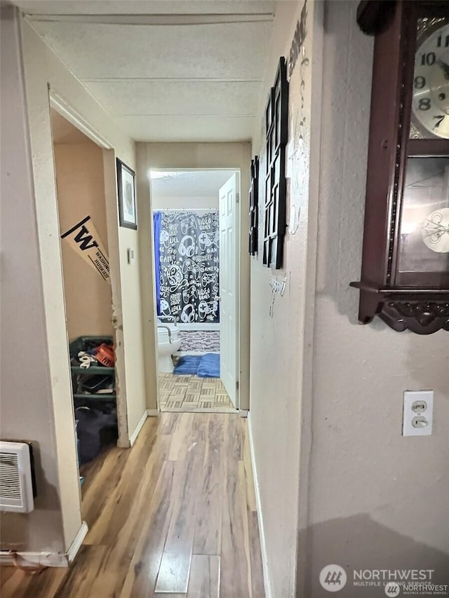 hallway featuring baseboards and wood finished floors