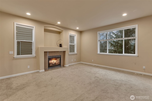 unfurnished living room featuring carpet floors, a fireplace, and recessed lighting