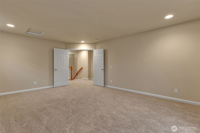 unfurnished room with attic access, recessed lighting, light colored carpet, and baseboards