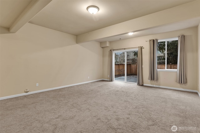 carpeted spare room with baseboards and beam ceiling