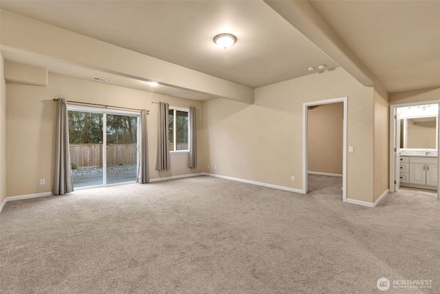 carpeted empty room featuring baseboards