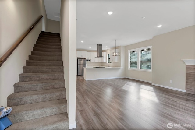 stairway featuring recessed lighting, baseboards, and wood finished floors