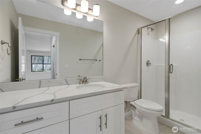 bathroom with vanity, toilet, and a shower stall