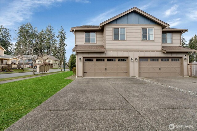 view of front facade featuring driveway, board and batten siding, a front yard, a shingled roof, and a garage