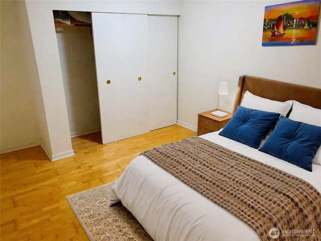 bedroom with baseboards, a closet, and light wood-style floors