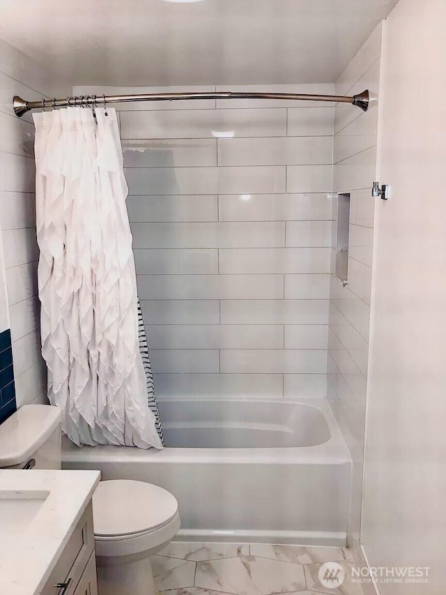 bathroom featuring toilet, marble finish floor, shower / bath combo with shower curtain, and vanity