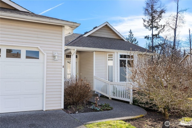 exterior space featuring roof with shingles and an attached garage