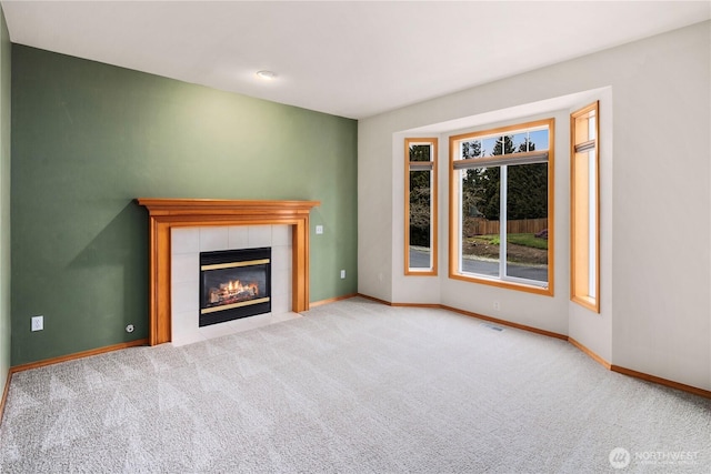 unfurnished living room featuring carpet, a fireplace, visible vents, and baseboards