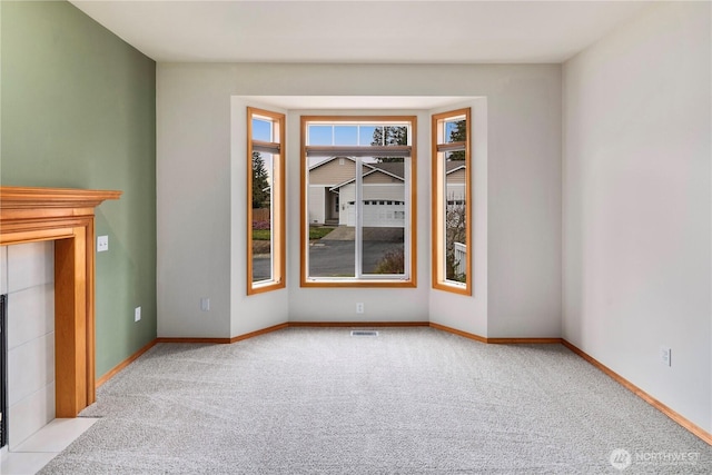 carpeted empty room with visible vents and baseboards