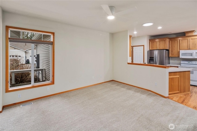 kitchen with light carpet, white appliances, baseboards, visible vents, and recessed lighting