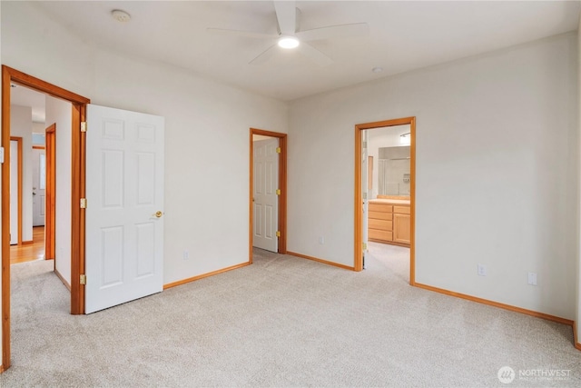 unfurnished bedroom with baseboards, ensuite bath, and light colored carpet