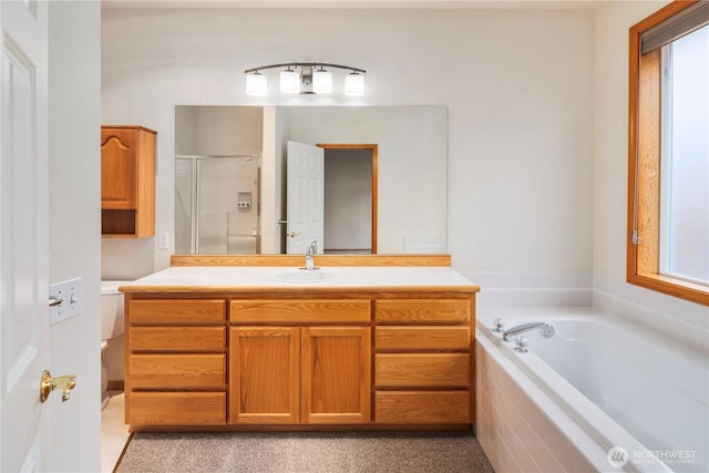 full bath with a stall shower, a healthy amount of sunlight, a garden tub, and vanity