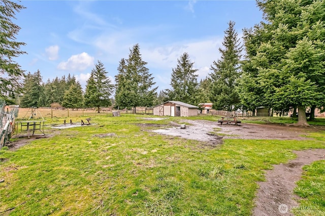 view of yard featuring fence and an outdoor structure