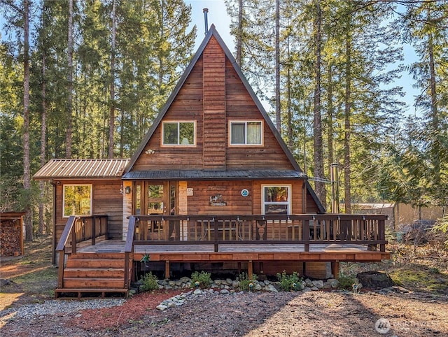 back of property featuring metal roof and a wooden deck