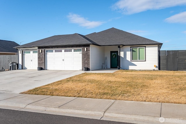 single story home featuring fence, concrete driveway, roof with shingles, a front yard, and a garage