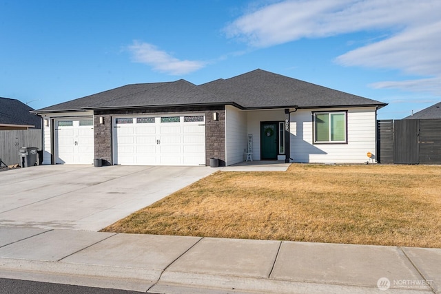 ranch-style house featuring roof with shingles, an attached garage, a front yard, fence, and driveway