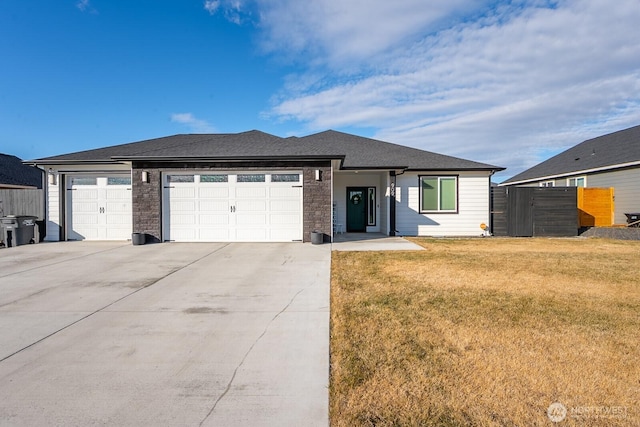 view of front of house featuring a garage, a front yard, concrete driveway, and fence