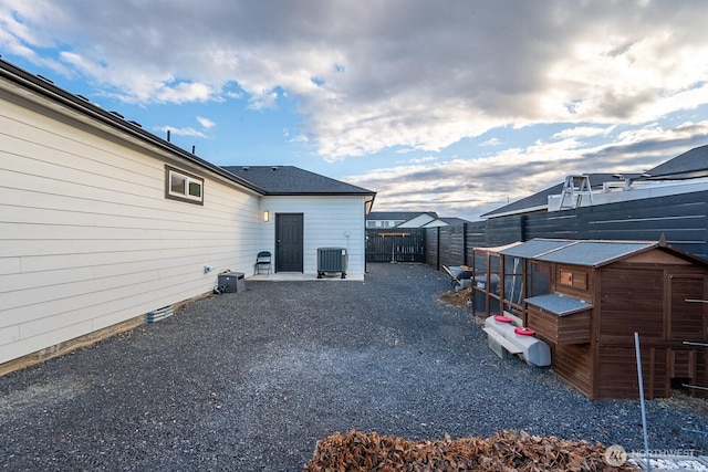 view of yard with fence private yard, exterior structure, central AC, and an outdoor structure