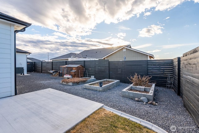 view of yard featuring a fenced backyard, a vegetable garden, and an outdoor structure